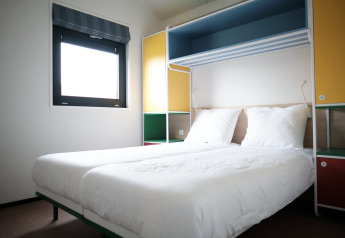 Habitación moderna en Resort Callantsoog 1, Países Bajos, con dos camas individuales y decoración colorida.