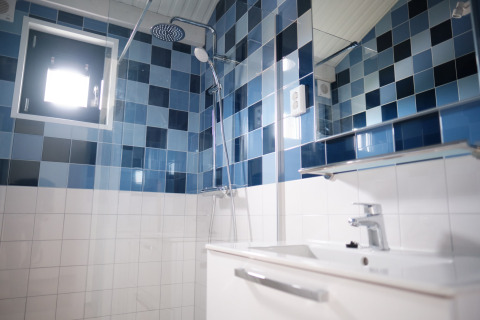 Modern bathroom at Resort Callantsoog 1 in the Netherlands with blue and white tiles, shower and sink.
