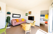Lyst opholdsstue med farverige møbler og adgang til soveværelse i Resort Callantsoog 5, Holland.