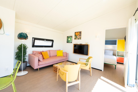 Lichte leefruimte met kleurrijk meubilair en slaapkamer in Resort Callantsoog 5, Nederland.