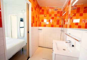 Moderne badeværelse i Resort Callantsoog 5 i Holland med orange fliser og regnbruser.