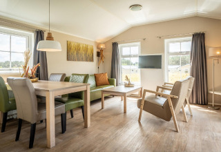 Soggiorno luminoso e accogliente presso Holiday Park «Loodsmansduin 1» nei Paesi Bassi, con arredi moderni.