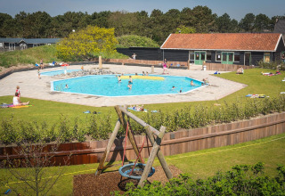 Udendørs poolområde på Holiday Park Loodsmansduin 1 i Holland, med børn der leger og folk solbader.