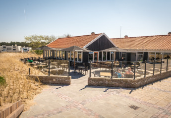 Outdoor patio at Holiday Park Loodsmansduin 1 in the Netherlands with seating and dune views.
