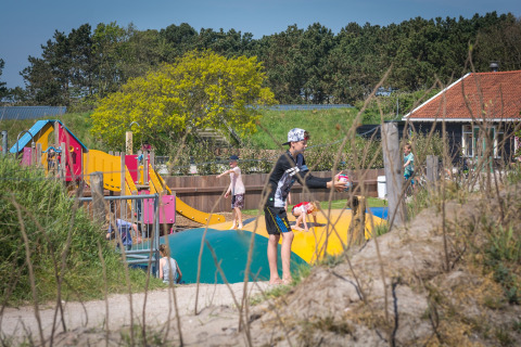 Kinder spielen auf einem Spielplatz mit Hüpfkissen im Holiday Park Loodsmansduin 1 in den Niederlanden.
