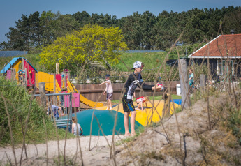 Children playing on a playground and bouncing pillow at Holiday Park Loodsmansduin 1 in the Netherlands.