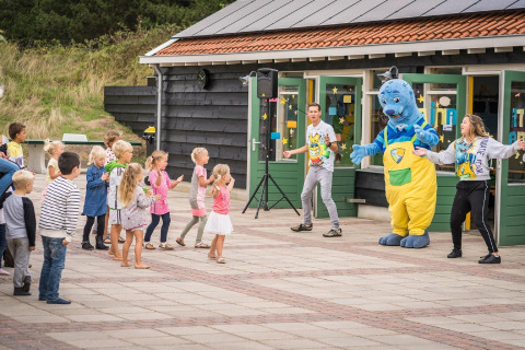 Bambini partecipano a giochi all'aperto con una mascotte al Holiday Park Loodsmansduin 1, Paesi Bassi.