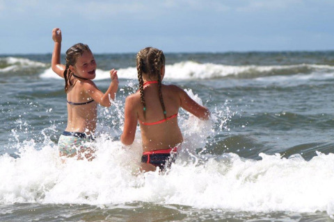 Deux enfants s'amusent dans les vagues sur la plage du Holiday Park «Loodsmansduin 1» aux Pays-Bas.