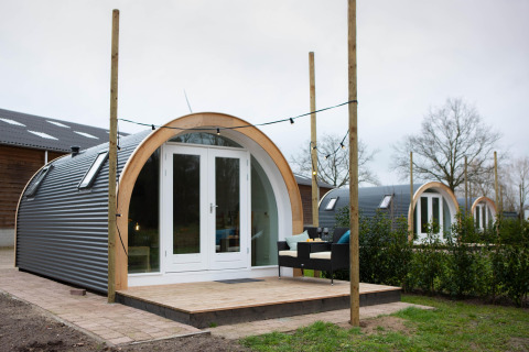 Et billede af De Ree en de Specht-podden med terrasse, udendørs siddepladser og flere pods bagved.