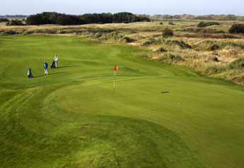 Golf course at Holiday Park Loodsmansduin 1 in the Netherlands, with players putting on a lush green fairway.