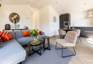 Moderne stue og køkken i et feriehus i Holiday Park Molenvelden 7, lyst indrettet med stilfulde møbler.