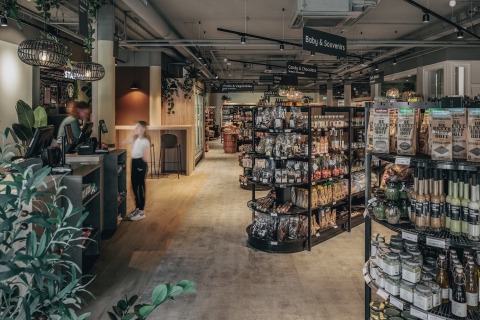 Indretning af en moderne lodge-butik med butikshylder, madvarer og en kasse, set indefra.