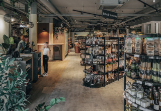 Indretning af en moderne lodge-butik med butikshylder, madvarer og en kasse, set indefra.