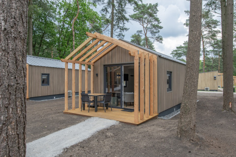 Foto di Forest Park 't Wolfsven 21, una tiny house in legno moderna nel bosco con veranda esterna.
