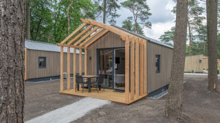Foto di Forest Park 't Wolfsven 21, una tiny house in legno moderna nel bosco con veranda esterna.