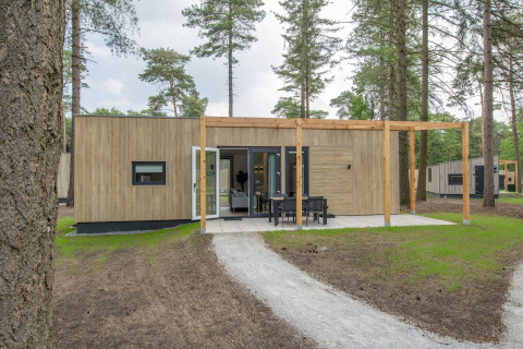 Moderne skovhytte i Forest Park 't Wolfsven 19 med træfacade, terrasse og udendørs spiseområde.