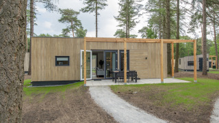 Lodge moderno al Forest Park 't Wolfsven 19 con esterno in legno, patio e zona pranzo all'aperto.
