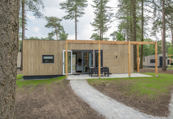 Lodge moderno en Forest Park 't Wolfsven 19 con fachada de madera, terraza y comedor exterior.