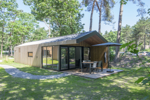 Chalet moderne en bois au cœur de la nature à Forest Park 't Wolfsven 15 avec terrasse et coin repas extérieur.