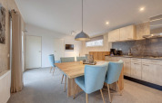 Bright dining and kitchen area in a modern lodge at Holiday Park Kijkduin 1, Netherlands, light décor.