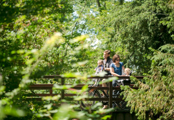 Eine Familie macht eine Radtour und genießt die grüne Natur im Holiday Park «Kijkduin 9» in den Niederlanden.
