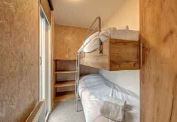 Camera con letto a castello in legno al Holiday Park «Kijkduin 1» nei Paesi Bassi con arredo minimale e accogliente.