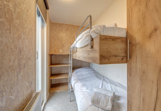 Camera con letto a castello in legno al Holiday Park «Kijkduin 1» nei Paesi Bassi con arredo minimale e accogliente.