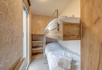 Modern wooden bunk bed room at Holiday Park 'Kijkduin 1' in the Netherlands, cozy and minimalistic decor.