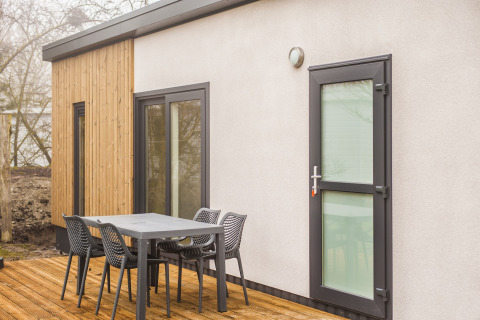 Patio esterno al Holiday Park «Kijkduin 1» nei Paesi Bassi con tavolo, sedie e facciata moderna.