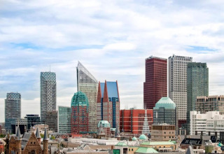 Vue panoramique de gratte-ciel modernes et d’immeubles uniques au cœur d’une ville européenne sous ciel nuageux.