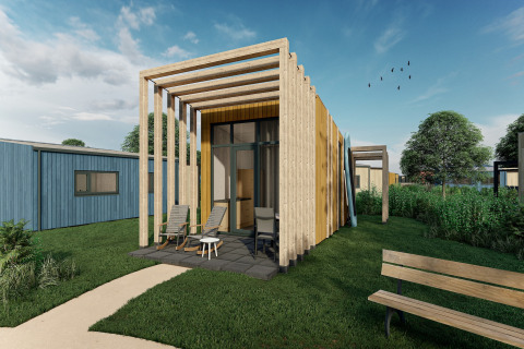 Casa pequeña moderna con fachada de madera y pérgola en Holiday Park Klein Vink 23, rodeada de vegetación.