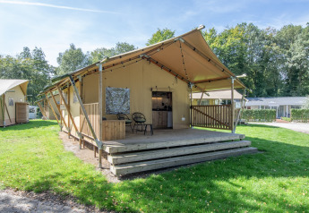 Safari-Zelt im Holiday Park Klein Vink 19 mit Holzterrasse und Sitzbereich in grüner, natürlicher Umgebung.