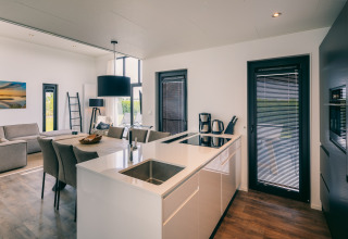 Moderne Küche und Wohnzimmer im Holiday Park Zeedijk 2 in den Niederlanden mit stilvoller Einrichtung.
