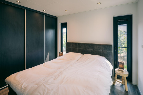 Chambre moderne au Holiday Park Zeedijk 2 aux Pays-Bas avec grand lit confortable et lumière naturelle.