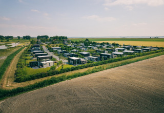 Vue aérienne du Holiday Park Zeedijk 2 aux Pays-Bas, entouré de champs et de lodges modernes.