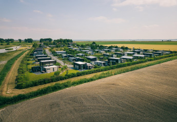 Aerial view of Holiday Park Zeedijk 2 in the Netherlands, showing modern lodges and farmlands.