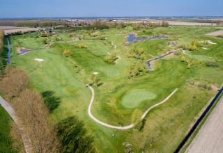 Luftfoto af Holiday Park «Zeedijk 2» i Holland, der viser grønne golfbaner og landskab, søer og små stier.