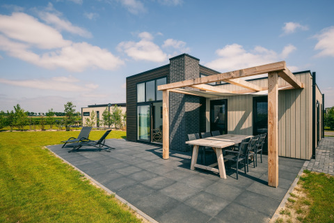 Lodge moderne à Holiday Park Zeedijk 2, Pays-Bas, avec grande terrasse et coin repas extérieur.