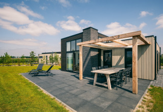 Lodge moderne à Holiday Park Zeedijk 2, Pays-Bas, avec grande terrasse et coin repas extérieur.