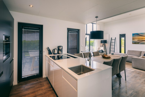 Modern open kitchen and living room with dining area at Holiday Park 'Zeedijk 2' in the Netherlands.