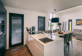Modern open kitchen and living room with dining area at Holiday Park 'Zeedijk 2' in the Netherlands.