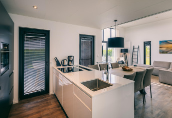 Modern open kitchen and living room with dining area at Holiday Park 'Zeedijk 2' in the Netherlands.
