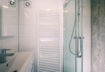 Modern bathroom with glass shower, sink, and towel radiator at Holiday Park Zeedijk 2 in the Netherlands.