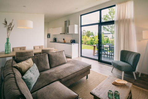 Modernes Wohnzimmer und offene Küche in einer Lodge im Holiday Park Zeedijk 1, Niederlande.