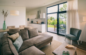 Modern living room and kitchen inside a lodge at Holiday Park Zeedijk 1 in the Netherlands, garden view.