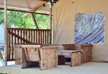 Area salotto all’aperto con sedie e tavolo in legno presso la tenda safari Beach Park «Vlugtenburg 13» nei Paesi Bassi.