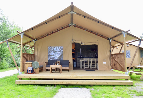Safari tent Beach Park Vlugtenburg 13 with wooden deck, outdoor seating, and grassy surroundings.