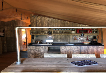 Area cucina in una tenda safari al Beach Park 'Vlugtenburg 13' nei Paesi Bassi, design rustico in legno.