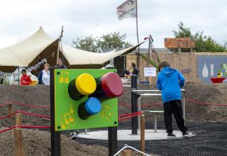 Children playing near colorful interactive installation at Beach Park Vlugtenburg 13 in the Netherlands.