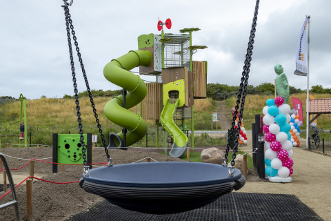 Playground with a slide, swing, and colorful balloons at Beach Park Vlugtenburg 13 in the Netherlands.